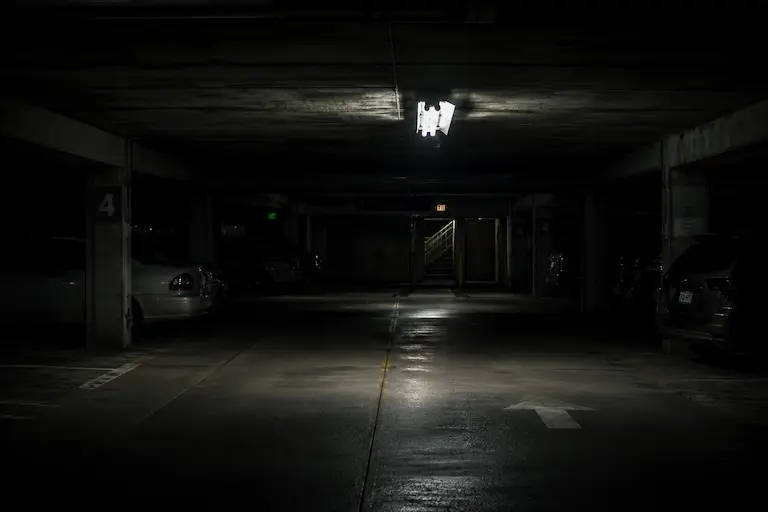 Dimly lit parking garage level | Denver parking lot assault lawyer | Lionheart Injury Law